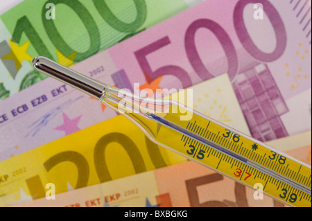 Fieberthermometer über Geld Banknoten Stockfoto