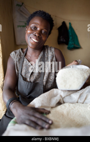 Frau Ruth Namuganza Kugeln Reis in ihrem kleinen Laden im Osten Wanyama, Jinja Bezirk, östlichen Uganda, Ostafrika. Stockfoto