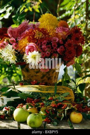 Stillleben mit Kanne bunte Chrysanthemen mit Gemüse Knochenmark und Äpfel im Herbst Blumenarrangement auf Tisch Stockfoto