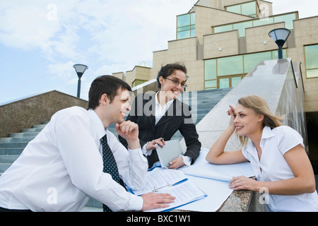 Team von sprechenden Nachwuchskräfte studieren, Skizzen, Zeichnungen und Dokumente an der Grenze zwischen der Außentreppe Stockfoto