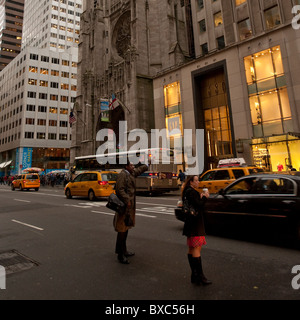 Menschen, die ein Taxi auf der Fifth Avenue in Manhattan, New York City, Vereinigte Staaten von Amerika Stockfoto