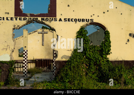 Einschusslöcher in der Wand einer zerstörten Kirche zeigen, dass Gewalt in den Slums von Cité Soleil vorhanden ist. Stockfoto