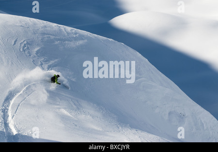 Telemark-Skifahrer machen eine Wende im Pulverschnee auf unwegsamem Gelände in Andermatt in der Schweiz. Stockfoto