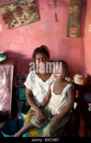 Eine Frau sitzt mit ihrem Kind in ihrem Wohnzimmer in Freetown, Sierra Leone, Westafrika. Stockfoto