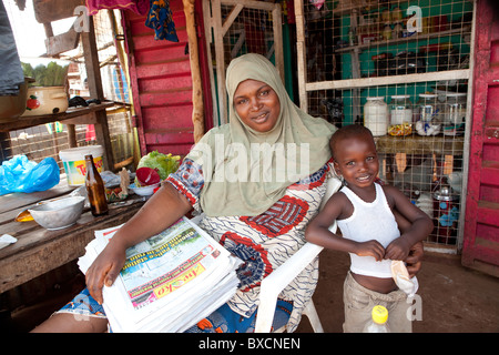 Frau Bella Bah, dargestellt mit ihrem Sohn Taiub Säge, verkauft Zeitungen in Funkia Nachbarschaft, Freetown, Sierra Leone, Westafrika. Stockfoto