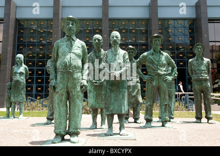 Grünspan Bronze-Statuen der Landarbeiter stehen in einer Menschenmenge Stockfoto