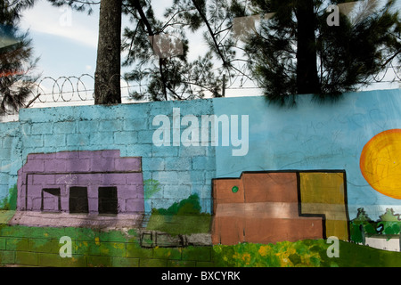 Malerei von Häusern und Gebäuden auf konkrete Cinderblock Mauer mit Stacheldraht Stockfoto