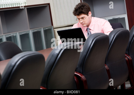 Porträt von Business-Mann am Tisch sitzen und mit Blick auf den laptop Stockfoto