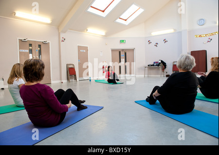 Ältere Damen, die Teilnahme an einer Pilates-Klasse für die über 50 Frauenlauf in einem Rat Tageszentrum. Stockfoto