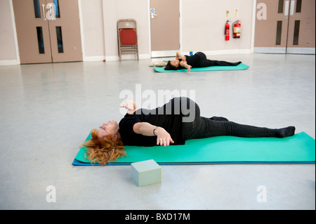 Ältere Weibchen spiegelt der Lehrer in einer Pilates-Klasse für die über 50 ist. Stockfoto