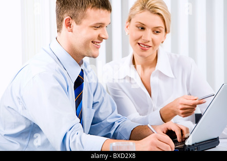 Business-Frau ist den richtigen Weg der Analyse ihrer Kollegin zeigt auf dem Bildschirm des Laptops erklären. Stockfoto