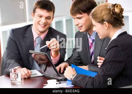 Zuversichtlich-Manager ist den richtigen Weg der Analyse an seine Kollegen im Büro auf dem Monitor zeigen erklären. Stockfoto