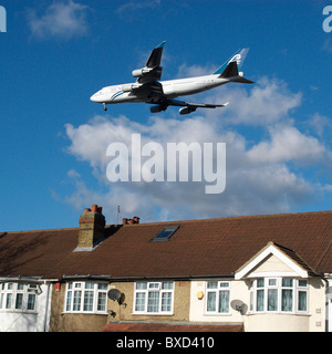 Flugzeug fliegen über Dächer in der Nähe von Heathrow Airport London UK Stockfoto