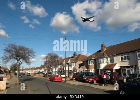 Flugzeug fliegen über Dächer in der Nähe von Heathrow Airport London UK Stockfoto