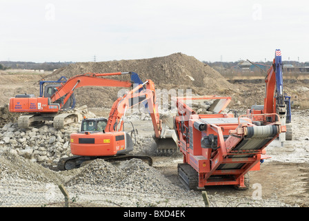 Bagger clearing eine abgerissene Seite mit einer aggregierten Brecher weichen für eine Papier-recycling-Anlage in Kings Lynn Norfolk UK Stockfoto