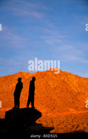 Zwei Silhouette männliche Rucksacktouristen posieren für ein Porträt beim stehen auf einem Steinhaufen beim Wandern durch Death Valley Confidenc Stockfoto