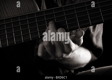 G-dur-Akkord auf 6-String E-Bass Gitarre (linke Hand), getönten Schwarz-Weiß-Bild Stockfoto