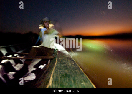 Dorian SImon Paddel eine große hölzerne Kanu bei Sonnenuntergang in Sandoval See. Stockfoto