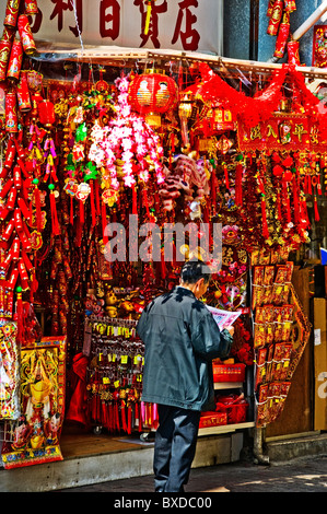 Orientalische Mann zu Fuß und lesen vor Geschenkladen in der Innenstadt von Hongkong China Stockfoto