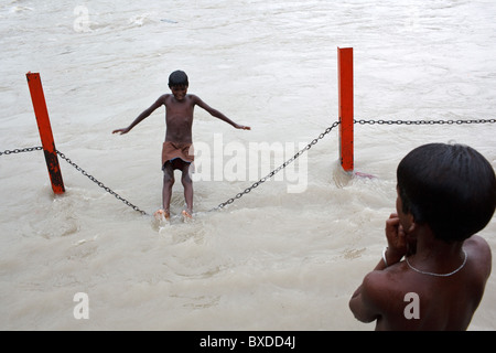 Zwei Jungs spielen in das Wasser im Fluss Ganges in Haridwar, Bundesstaat Uttarakhand, Indien Stockfoto