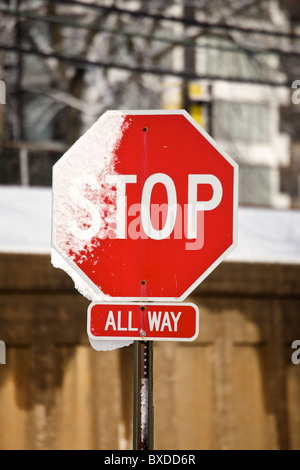 Stop-Schild teilweise mit Schnee bedeckt. Stockfoto