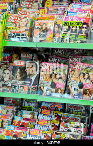 Zeitschriften zum Verkauf auf dem Nachrichtenstand im Asda Supermarkt, Großbritannien Stockfoto