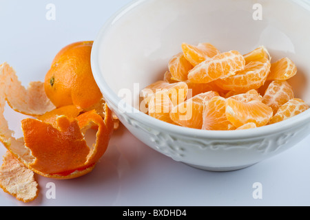 Geschälte Clementinen in weiße Schüssel auf weiße Fläche Stockfoto