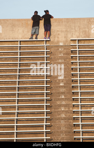 jungen und Mädchen stehen auf der obersten Zeile der Tribüne Blick über den konkreten Rand des Stadions in Austin, Texas, USA Stockfoto