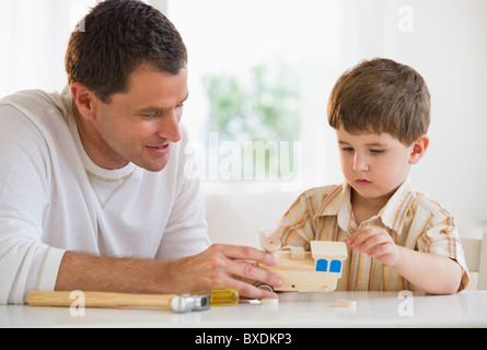 Vater und Sohn eine Holzeisenbahn Gebäude Stockfoto