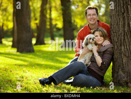 Glückliches junges Paar hält einen Shih Tzu Hund im freien Stockfoto