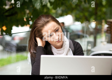 Junge Frau mit einem Laptop im freien betonte Stockfoto