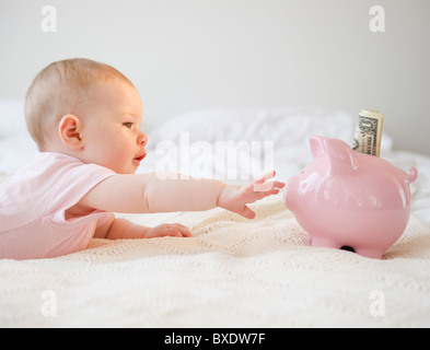 Baby für Sparschwein zu erreichen Stockfoto