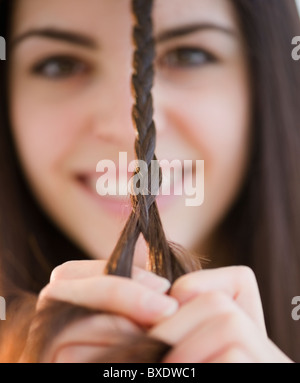 Junge Frau, ihr Haar zu flechten Stockfoto