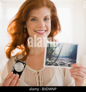 Frau Holding Kamera und Foto Stockfoto