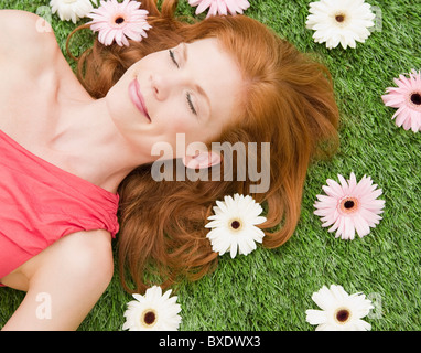 Schöne Frau entspannend auf Rasen Stockfoto