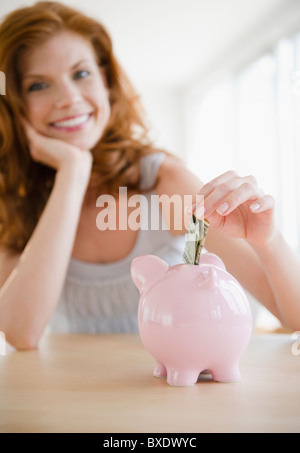 Frau, Geld im Sparschwein Stockfoto
