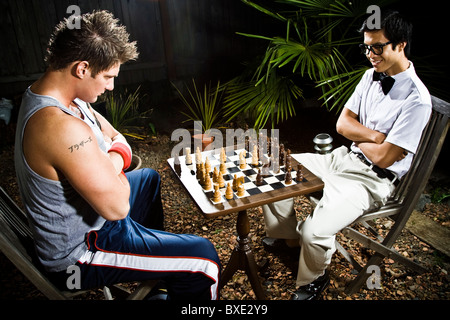 Geek und Body Builder Schach spielen Stockfoto