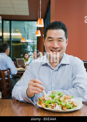 Mann isst Salat im restaurant Stockfoto