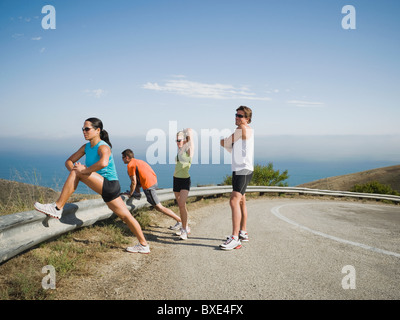 Läufer, die am Straßenrand dehnen Stockfoto