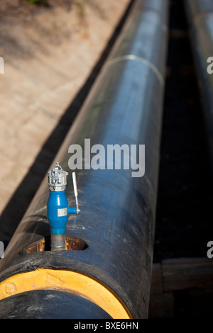 Wasser Auslass ventil auf isolierte PVC-Rohren auf u-Fernwärme Pipeline abgedeckt Stockfoto