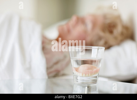 Zahnersatz in einem Glas Wasser Stockfoto