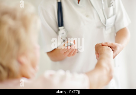 Krankenschwester Einnahme Puls der älteren Frau Stockfoto