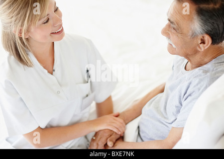 Krankenschwester mit Patienten sitzen Stockfoto