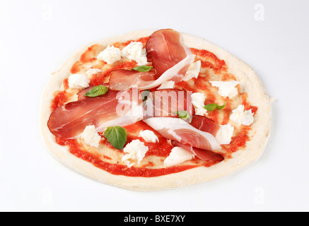 Rohen Pizzateig mit Mozzarella und Prosciutto an der Spitze Stockfoto