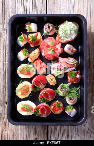 Auswahl an Hors d ' Oeuvre auf einem schwarzen Tablett Stockfoto