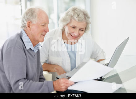 Älteres paar Papierkram zusammen zu machen Stockfoto