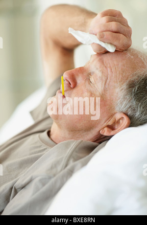 Ältere Menschen mit einem Thermometer in den Mund Stockfoto