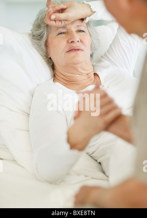 Mann, die Fürsorge für ältere Frau mit Kopfschmerzen Stockfoto