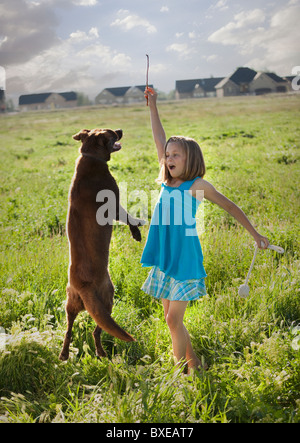 Junge Mädchen spielen mit ihrem Hund Stockfoto