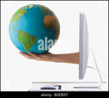 Globus auf Arm gestreckt aus Computer-monitor Stockfoto